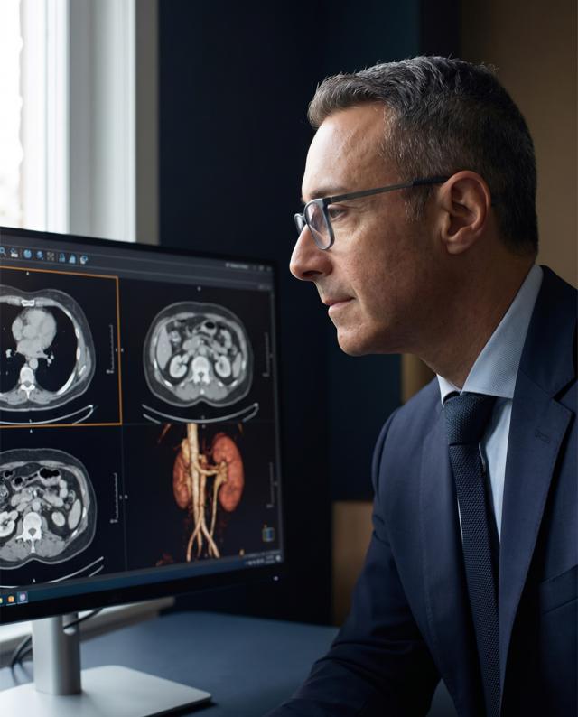 El Dr. Vitagliano revisa estudios por imágenes en una pantalla.