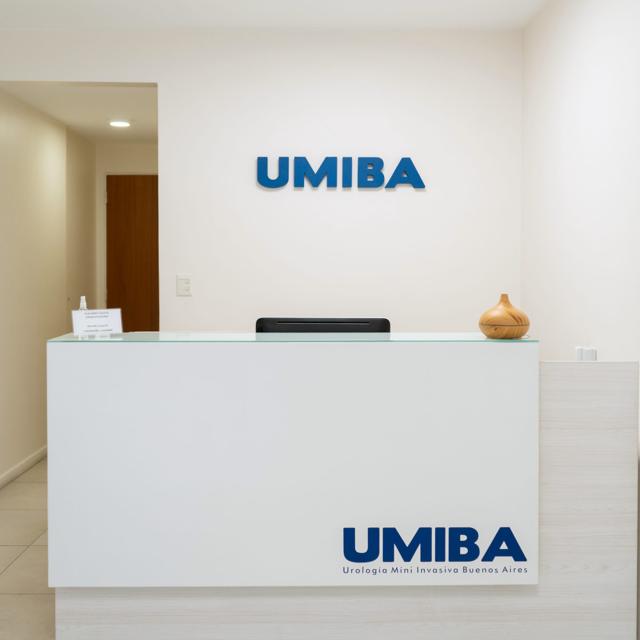 Recepción de UMIBA en Recoleta: mostrador blanco con el logotipo de UMIBA y el letrero institucional en la pared.